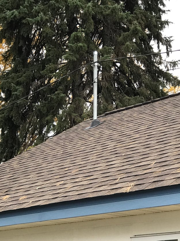 Raised service mast for overhead power line clearance on detached garage roof